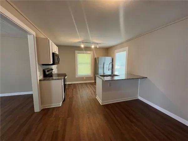 a view of open kitchen with wooden floor and electronic appliances