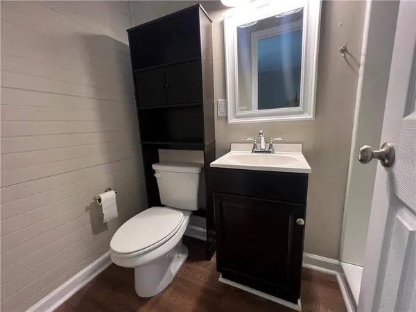 a bathroom with a toilet sink and mirror