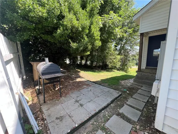 a view of a backyard with chairs and a patio