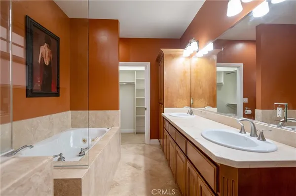 a bathroom with a tub sink and mirror