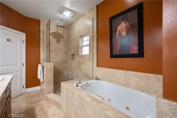 a bathroom with a tub a sink and glass door