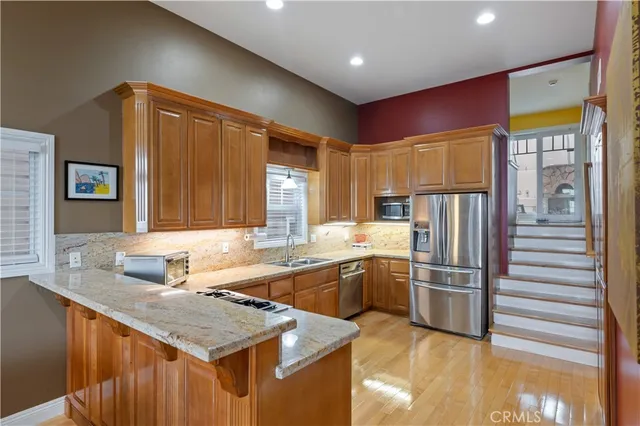 a kitchen with stainless steel appliances granite countertop a sink stove and refrigerator