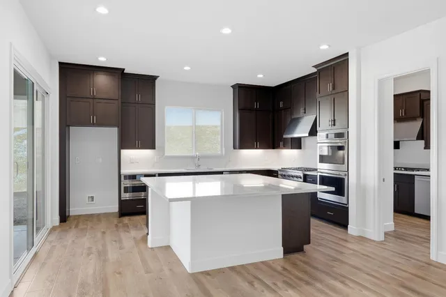 a kitchen with stainless steel appliances granite countertop a stove and a refrigerator