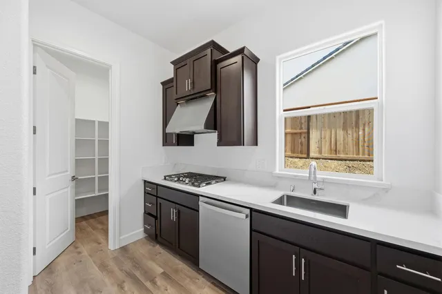 a kitchen with a sink cabinets and a window