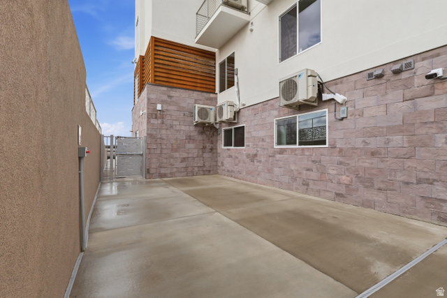2085 North Main Street, Unit 409 Sunset, UT 84015 - Photo 16 of 17 View of sun deck exterior featuring a gate, a patio, and stucco siding