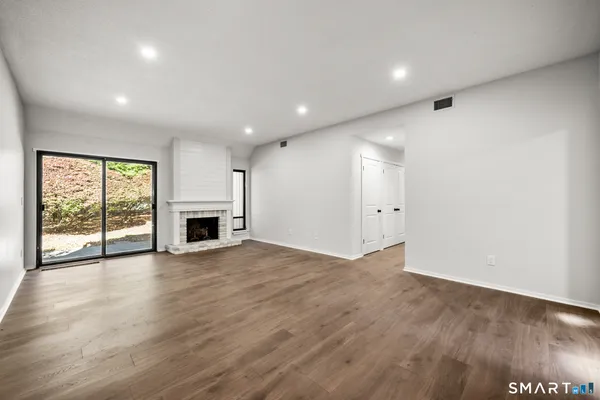an empty room with wooden floor and fireplace