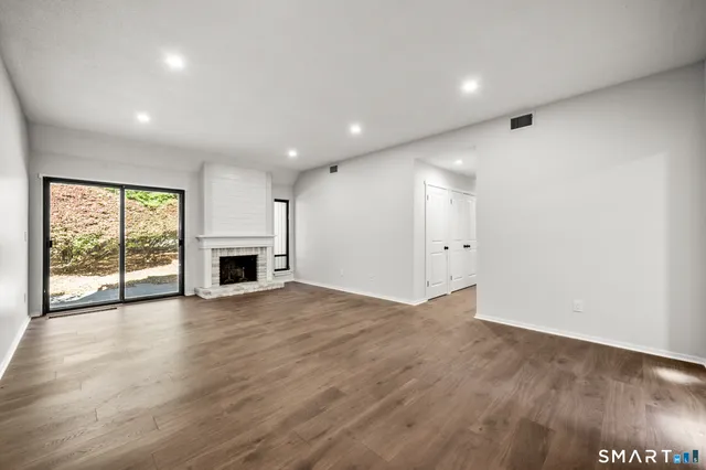 an empty room with wooden floor and fireplace