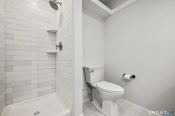 a bathroom with a toilet and a shower