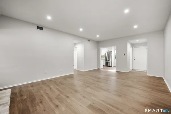 a view of an empty room with wooden floor