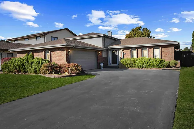 a front view of a house with a garden and plants
