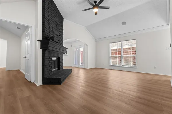a view of empty room with wooden floor and fireplace