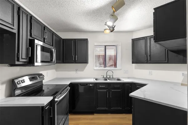 a kitchen with stainless steel appliances granite countertop a sink stove and microwave