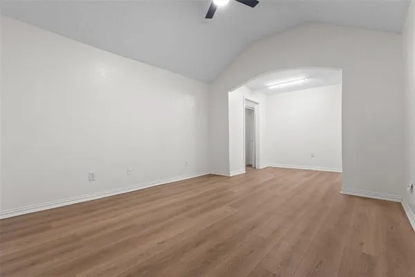a view of an empty room with wooden floor