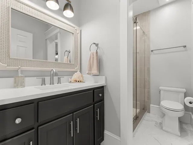 a bathroom with a sink a toilet and shower