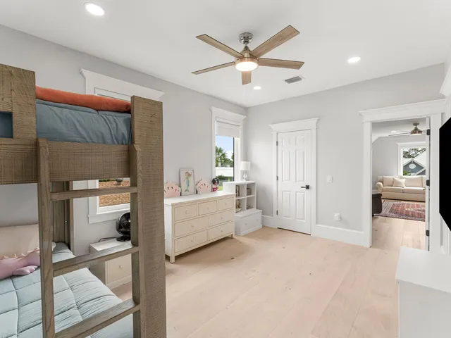 a view of a swimming pool with a lounge chair and a large tree