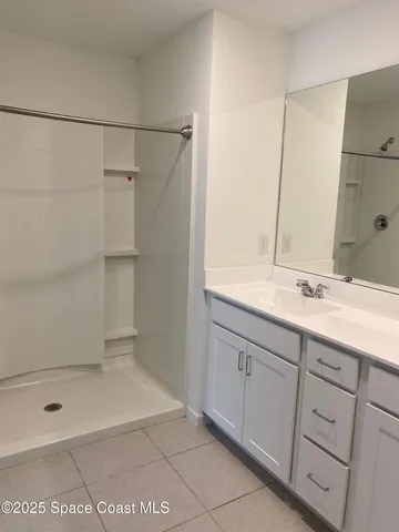 a bathroom with a shower sink and vanity