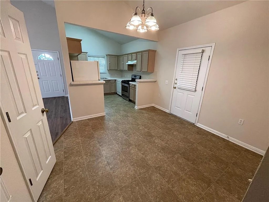 5701 Signal Point Austin, TX 78724 - Photo 3 of 12 Open concept living space featuring a vaulted ceiling and durable tile-look flooring
