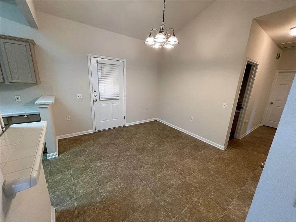 5701 Signal Point Austin, TX 78724 - Photo 6 of 12 Dining area featuring vaulted ceilings, a five-light chandelier, and tile-finish flooring