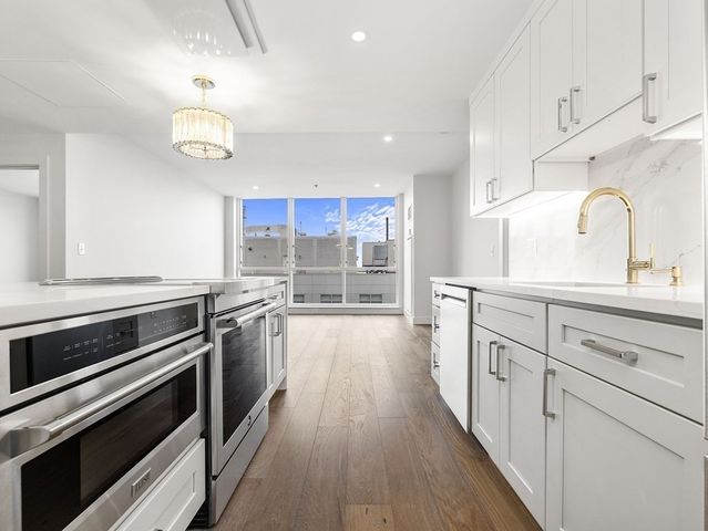 a kitchen with stainless steel appliances granite countertop a sink stove and cabinets