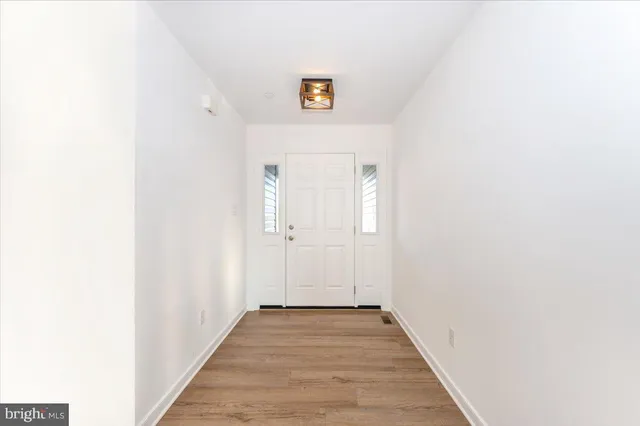 a view of a hallway with wooden floor