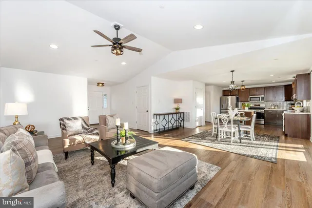 a living room with furniture couches and a dining table with kitchen view