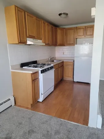 a kitchen with stainless steel appliances granite countertop a stove a refrigerator a sink dishwasher and a refrigerator with wooden cabinets