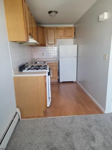 a view of kitchen with refrigerator stove and a window