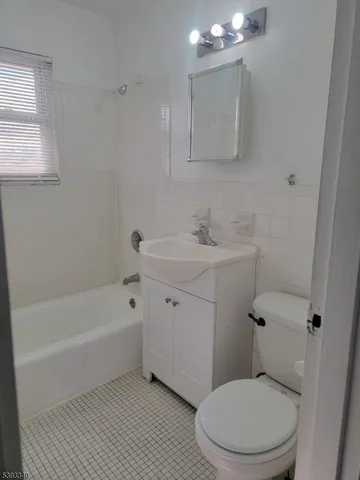 a bath room with a toilet a sink and a bath tub
