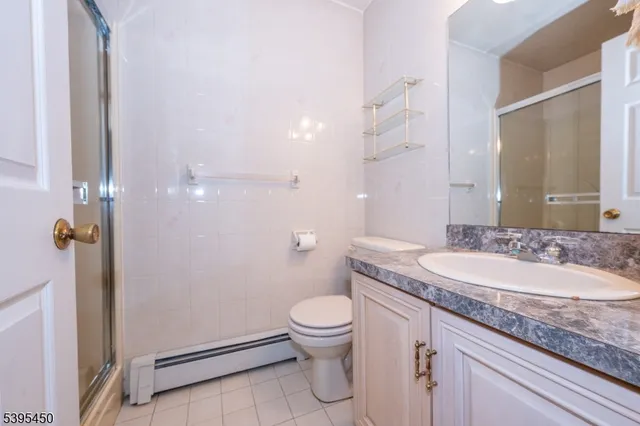 a bathroom with a granite countertop sink a toilet and a mirror