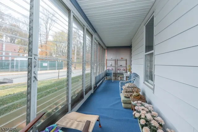 a hallway with hardwood floor and a large window