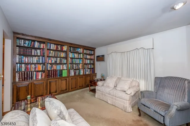 a living room with furniture and a book shelf