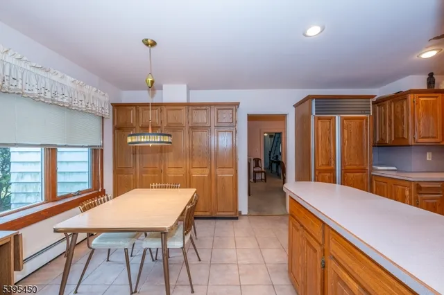 a kitchen with a table chairs refrigerator and cabinets
