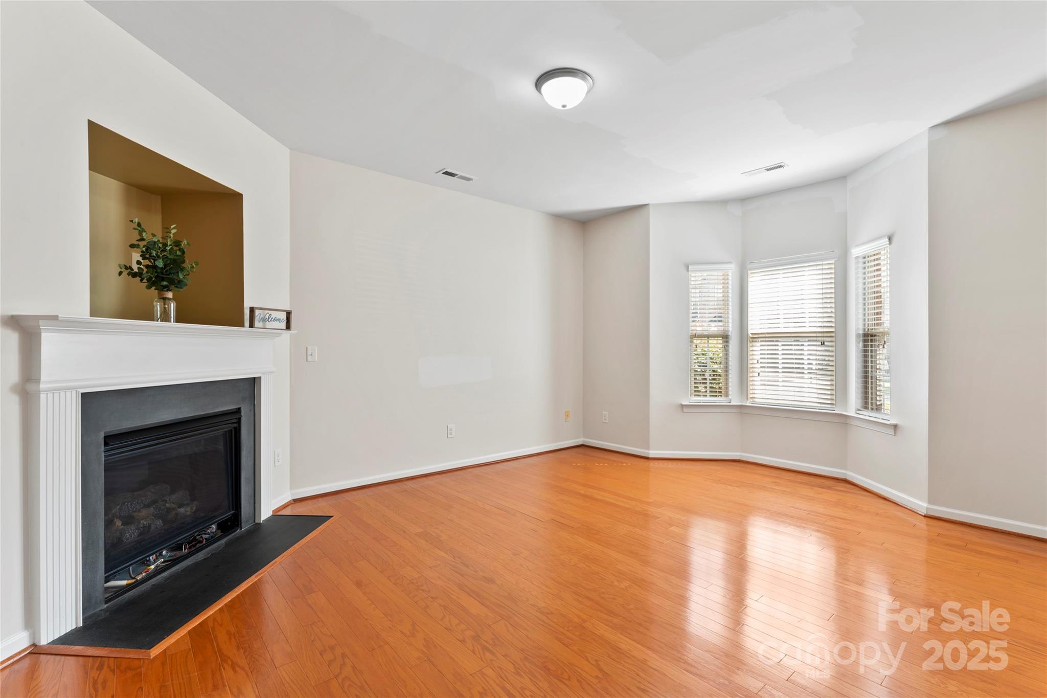 5678 Stafford Road Charlotte, NC 28215 - Photo 8 of 43 a view of empty room with wooden floor and fireplace