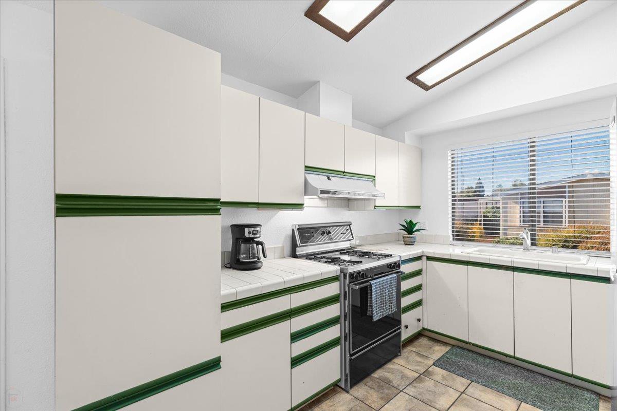 1500 Held Drive, Unit 79 Modesto, CA 95355 - Photo 13 of 58 a kitchen with a sink a stove and cabinets