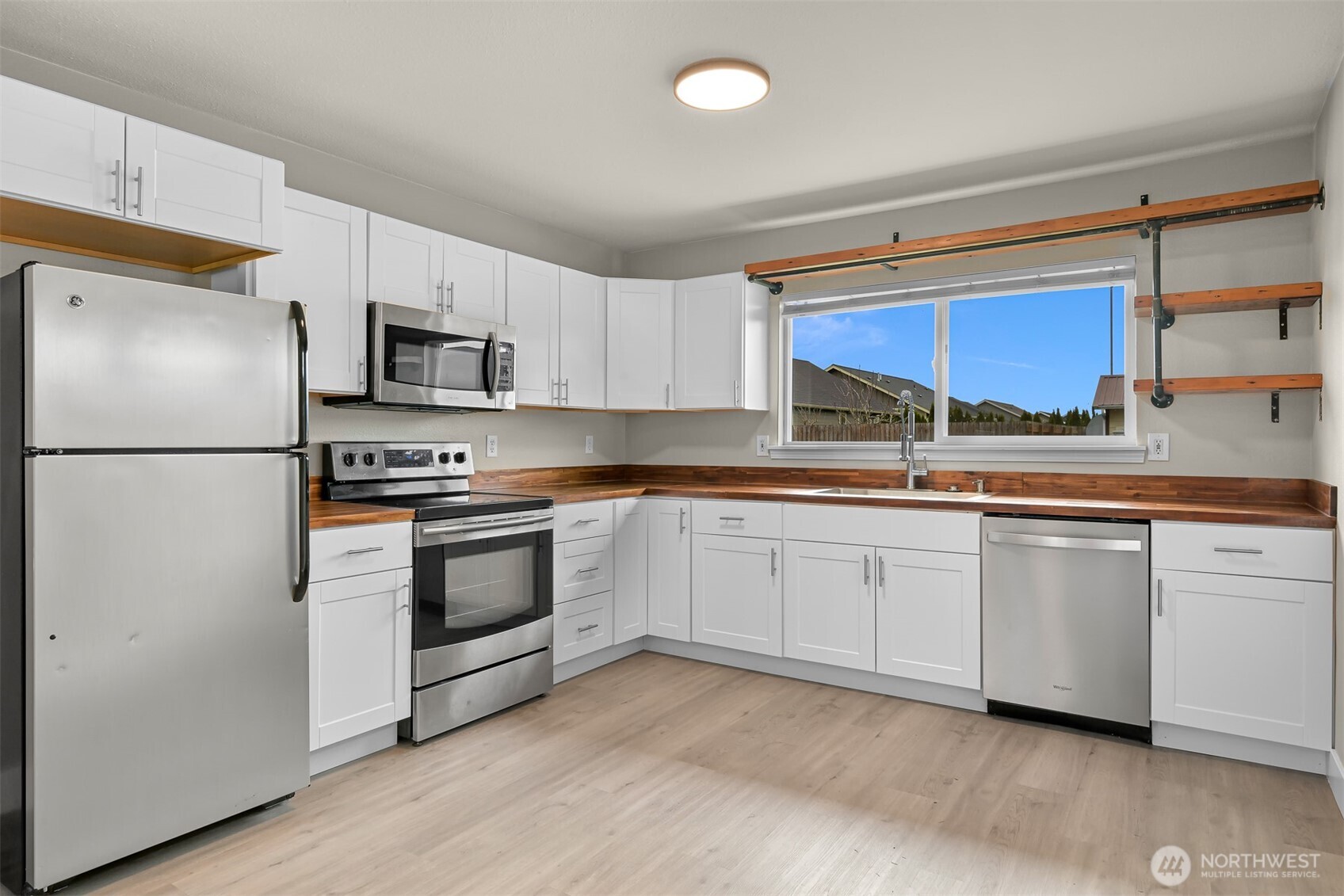 310 West 3rd Street Nooksack, WA 98276 - Photo 11 of 34 a kitchen with granite countertop white cabinets and stainless steel appliances