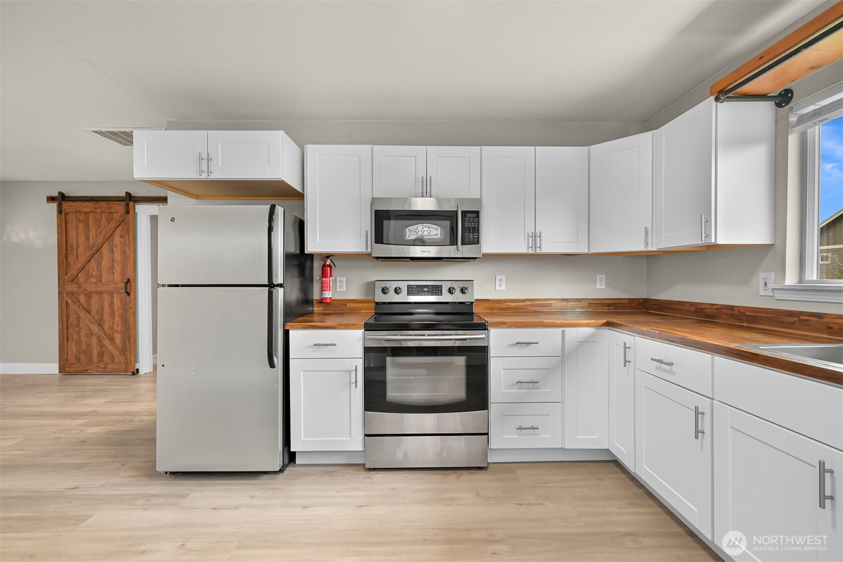 310 West 3rd Street Nooksack, WA 98276 - Photo 12 of 34 a kitchen with a refrigerator stove and white cabinets