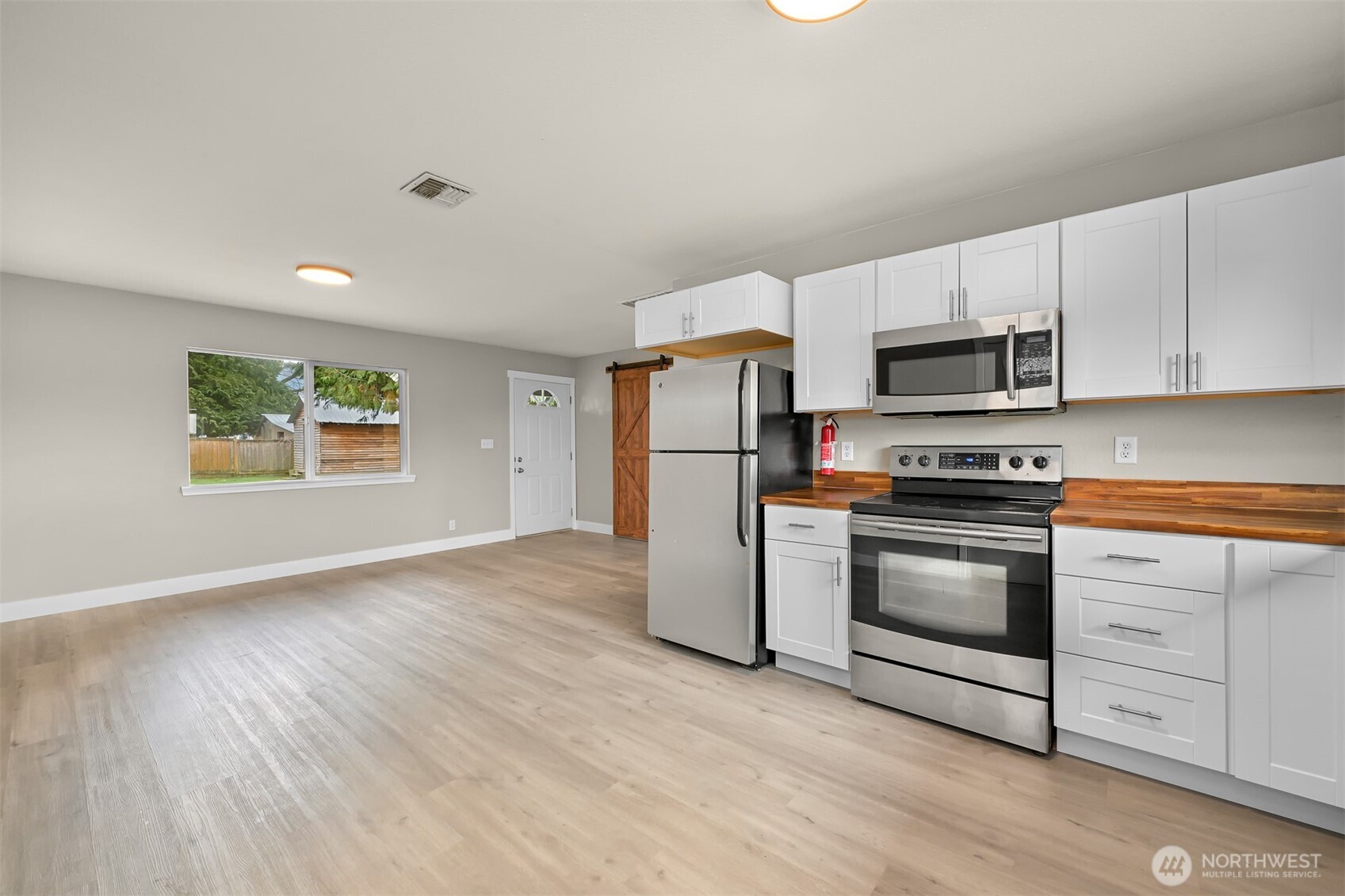 310 West 3rd Street Nooksack, WA 98276 - Photo 13 of 34 a kitchen with granite countertop a refrigerator stove and microwave