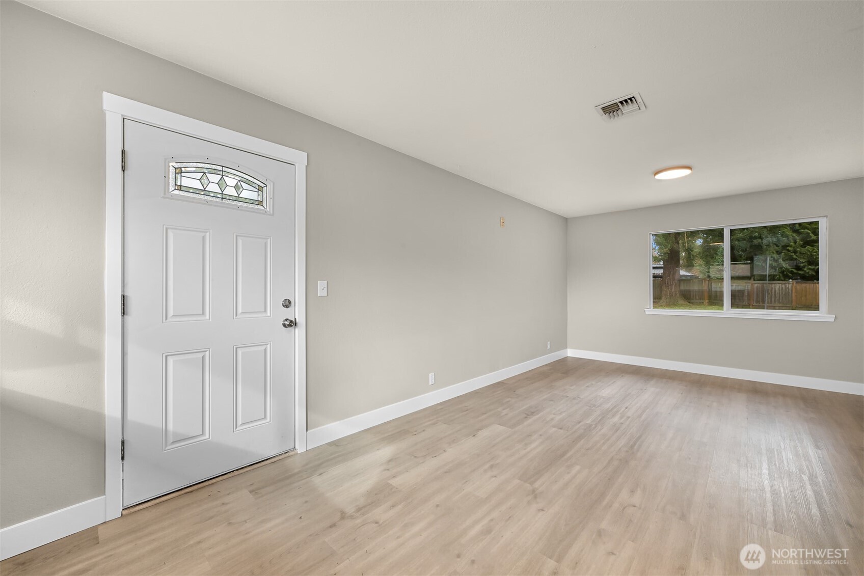 310 West 3rd Street Nooksack, WA 98276 - Photo 7 of 34 a view of an empty room with wooden floor and a window