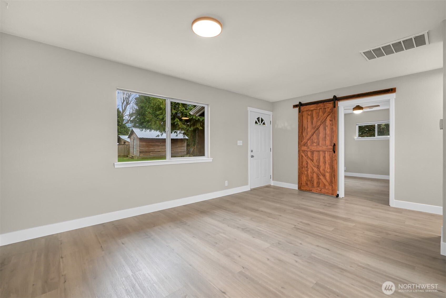 310 West 3rd Street Nooksack, WA 98276 - Photo 8 of 34 an empty room with wooden floor and windows