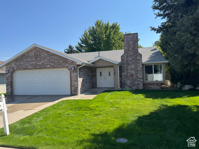1789 West 5000th Street South Roy, UT 84067 - Photo 1 of 1 Ranch-style house featuring a front yard, a shingled roof, an attached garage, concrete driveway, and brick siding