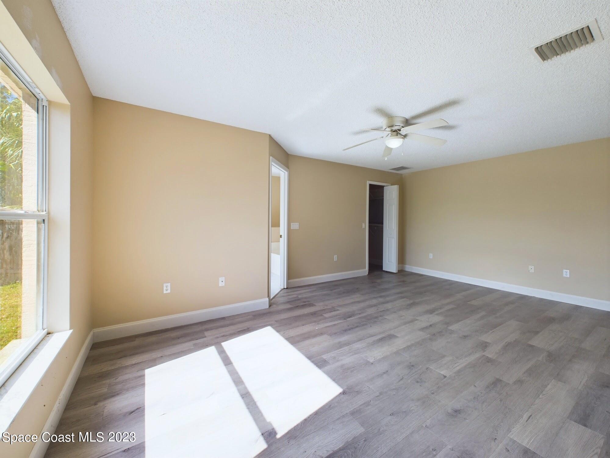248 Benchor Road Northwest Palm Bay, FL 32907 - Photo 12 of 31 a view of a big room with windows and chandelier fan