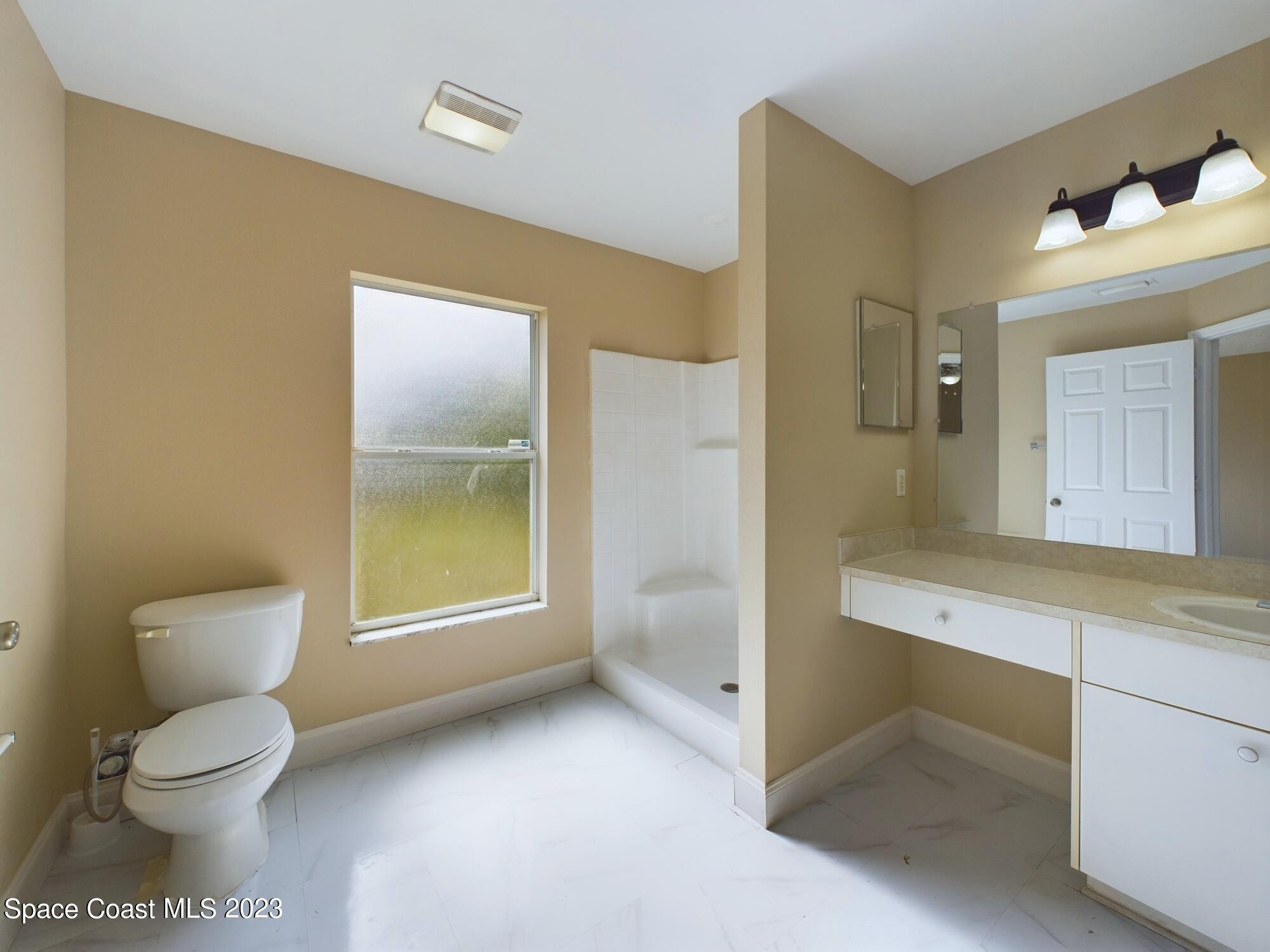 248 Benchor Road Northwest Palm Bay, FL 32907 - Photo 14 of 31 a bathroom with a toilet sink and mirror