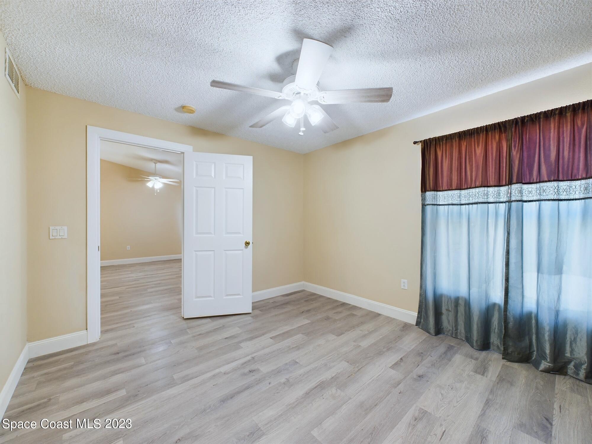248 Benchor Road Northwest Palm Bay, FL 32907 - Photo 17 of 31 wooden floor in an empty room with a window