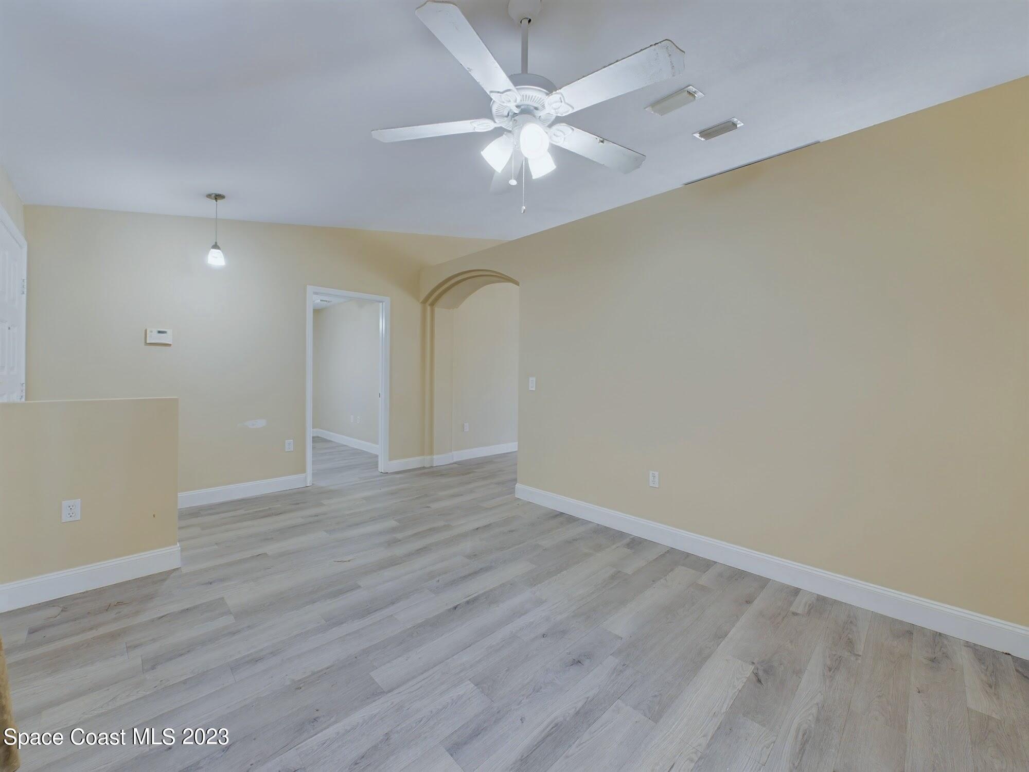 248 Benchor Road Northwest Palm Bay, FL 32907 - Photo 5 of 31 an empty room with wooden floor and fan
