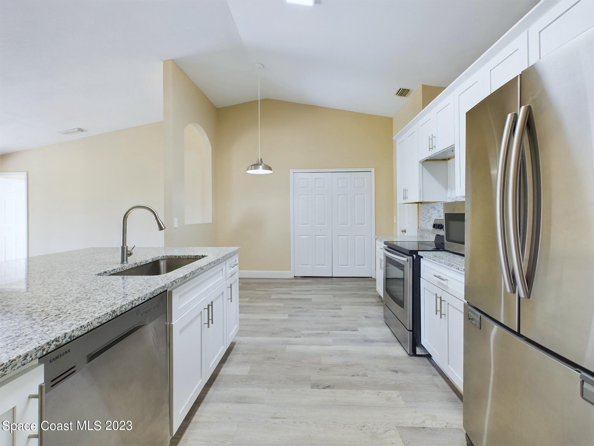 248 Benchor Road Northwest Palm Bay, FL 32907 - Photo 8 of 31 a kitchen with a sink and a refrigerator