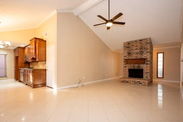 a view of a livingroom with a fireplace and a ceiling fan