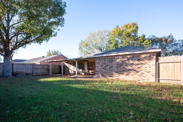 a view of a house with a yard and sitting area