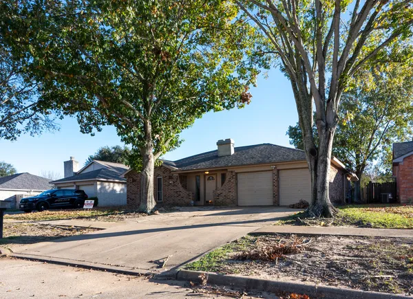 a front view of a house with a tree in it