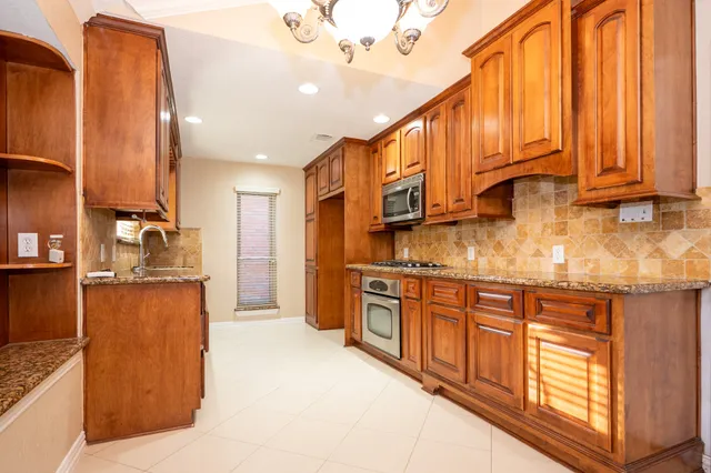 a kitchen with stainless steel appliances granite countertop a stove a sink and a refrigerator
