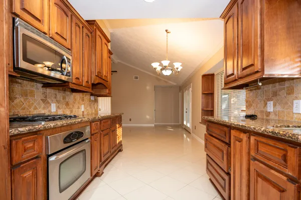 a kitchen with stainless steel appliances granite countertop a stove and a microwave